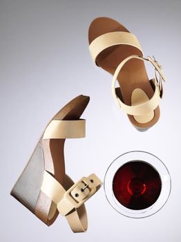 woman's summer season sandals and glass of red wine