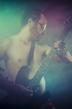 Metal, rocker man with electric guitar in a rock concert