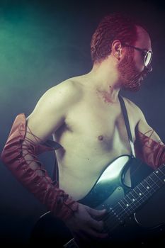 Metal, rocker man with electric guitar in a rock concert