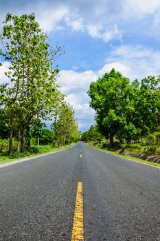 Long road passes through green countryside