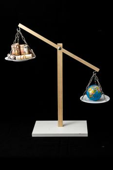 Globe Planet Earth and Money on a Two Pan Balance