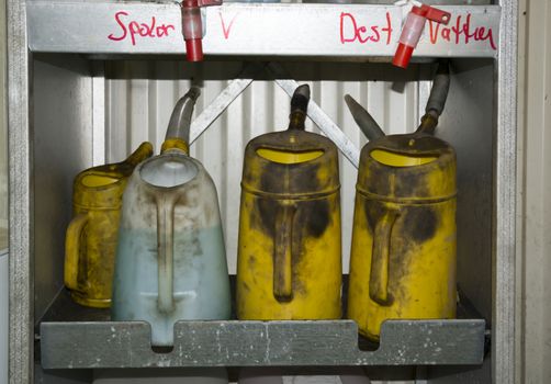 Greasy liquid cans with washer fluid and destilled water. Car mechanic garage switch to or from summer or winter tires.