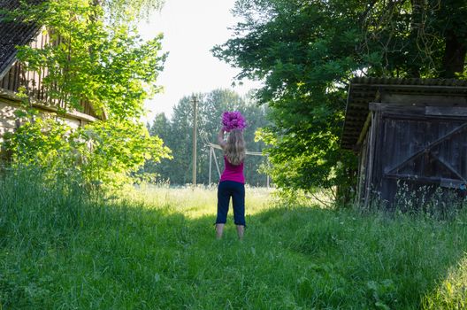 blonde gracefully woman pose with flower on sunlit summer garden background