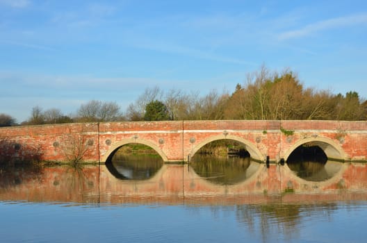 Large arched redbrick river bridge in suffolk