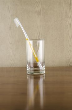 toothbrush in glass on wood background