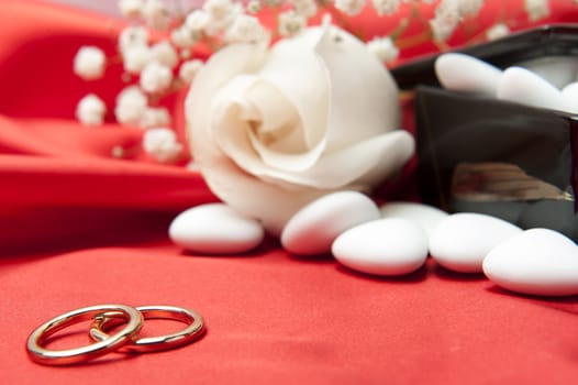  wedding rings and wedding favors on  elegant fabric background