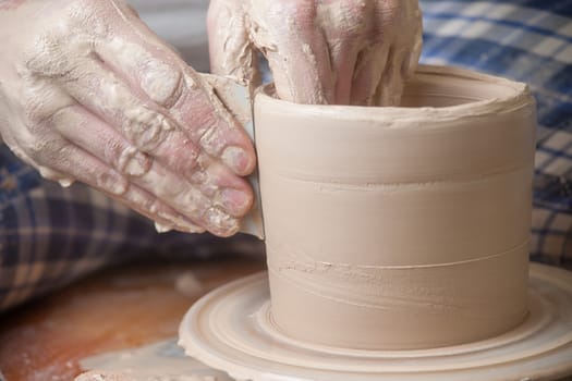 Hands of a potter, creating an earthen jar on the circle