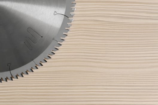 sharp circular saw on wood background bleached pine