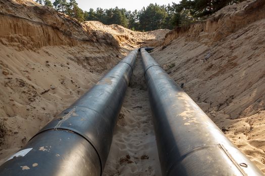 A uncovered pipeline construction site with sand around it