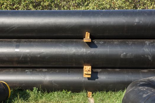 A stacked pile of black pipes for later useage