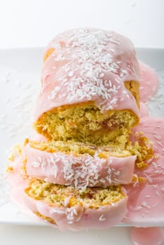 sliced delicious small cake with strawberry icing filling and coconut topping
