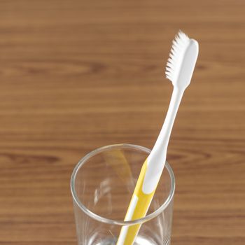 toothbrush in glass on wood background