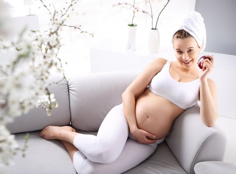 Pregnant woman holding her hand on her stomach waiting for the baby's movements