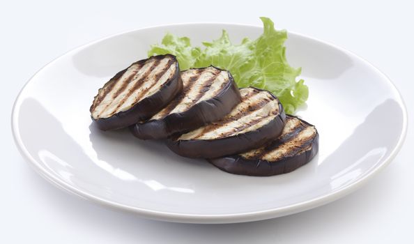 Some fried slices of eggplant with fresh green lettuce on the plate