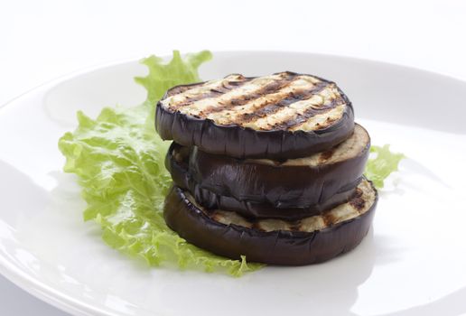 Some fried slices of eggplant with fresh green lettuce on the plate