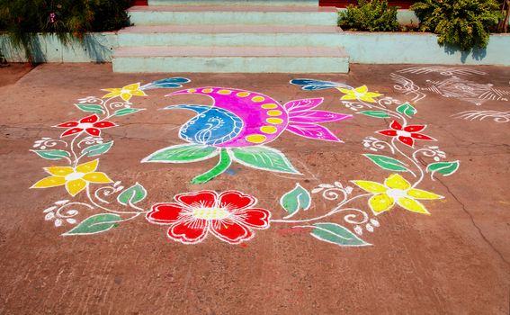 Traditional Rangoli Design with Coloured Powders in Floral Design at the Doorsteps of an Indian House