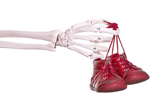 skeleton hand holding old red baby shoes