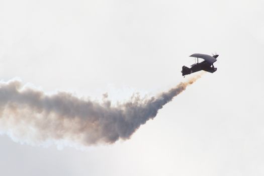 Biplane performing aerobatics with smoke