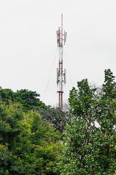 communications tower on the building with green trees