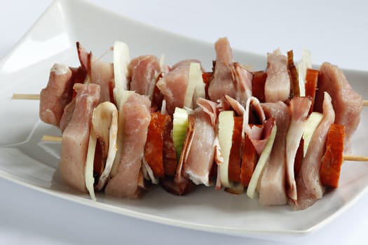 Detail of the raw pork skewers - mixture of meat, sausages and onions