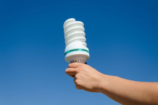 hand hold economical power ecology white bulb on blue sky background