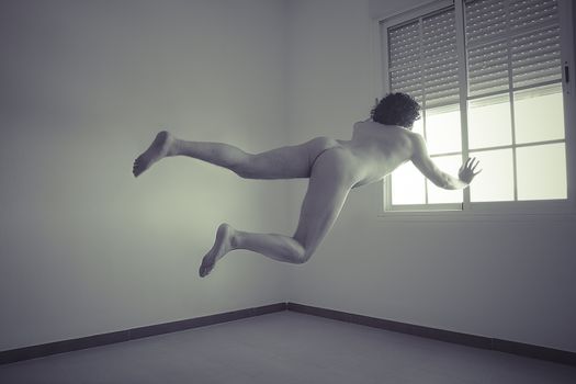 nude man flying into a window, concept of freedom and imagination