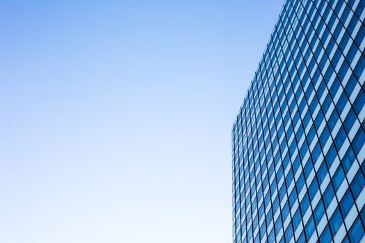 Exterior of building - abstract concept; skyscraper from down below against blue sky