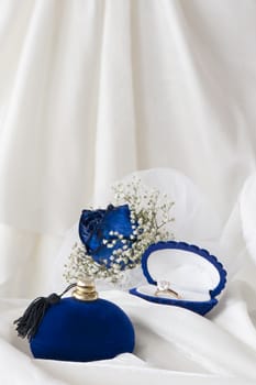 a  blue roses and wedding rings on white background