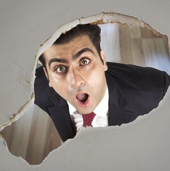 Man looking through a hole in the ceiling 