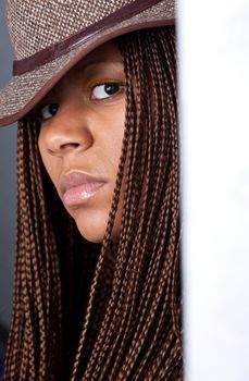 portrait of a young woman with African braids and hat
