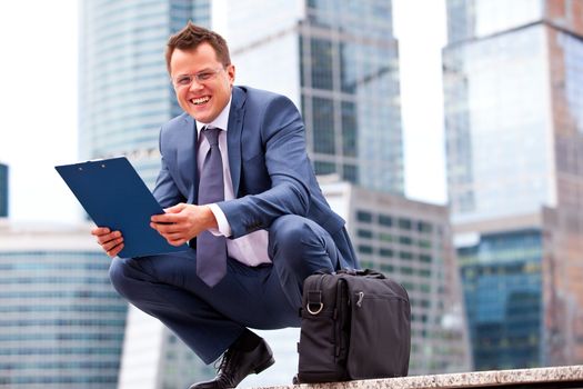 Successful businessman smiling on the background of office towers