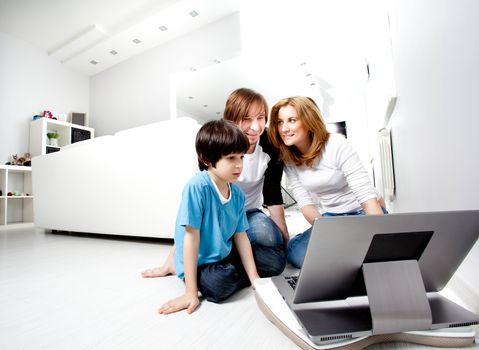 Young parents with child near laptop computer