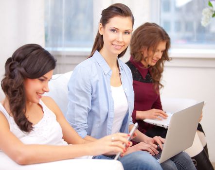 three young  woman resting with notebook on sofa, at campus