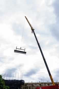 Crane hoist concrete plate at construction site