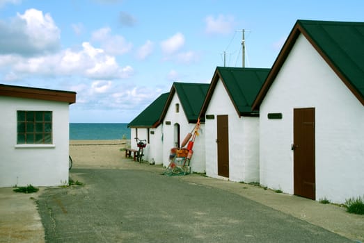White fishing huts at a beach in Denmark.