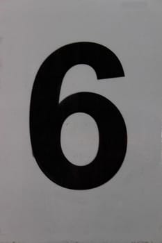 black displayed number six on a gray background