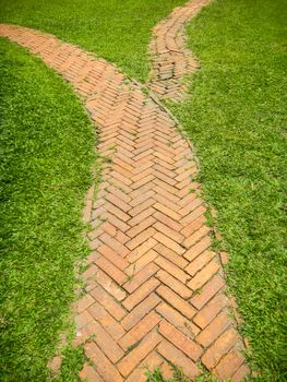 Brick walkway in the park on green grass