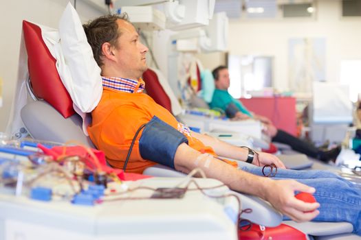 Blood donor at donation with a bouncy ball holding in hand.