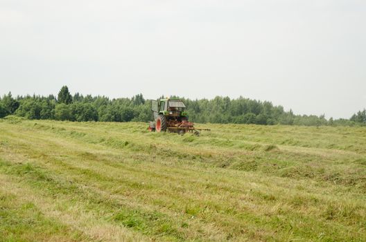 field work equipment tractor with hay shaker work outside