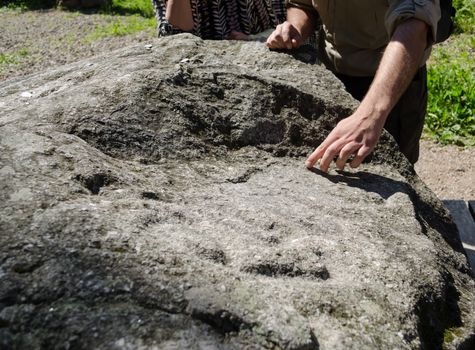 male hand show signs taken of the mysterious large stone flat surface