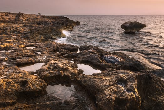 rock reef in the sea at sunset