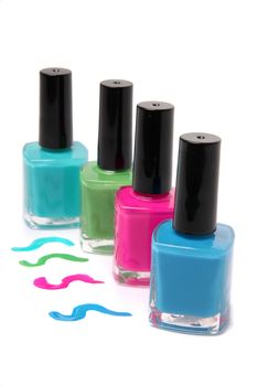 Nail polish bottles and spots in bright spring or summer colors in light blue, pink and green on a white background