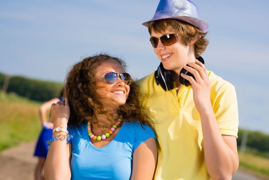 young couple standing on the road, having fun with friends