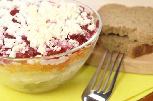 Russian traditional herring salad in glass bowl