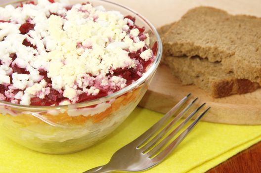 Russian traditional herring salad in glass bowl