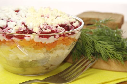 Russian traditional herring salad in glass bowl