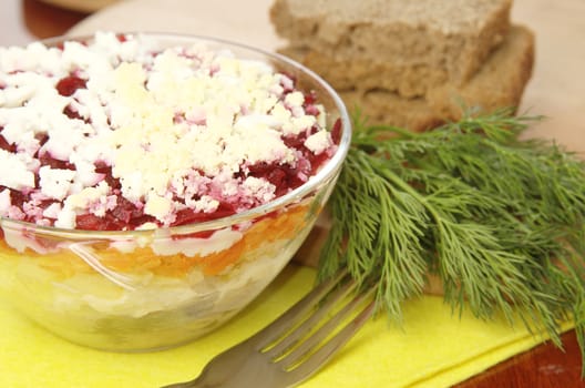 Russian traditional herring salad in glass bowl