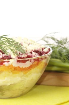 Russian traditional herring salad in glass bowl