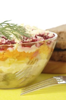 Russian traditional herring salad in glass bowl