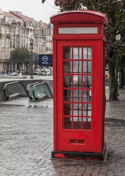 Old red telephone booth in Porto, Portugal